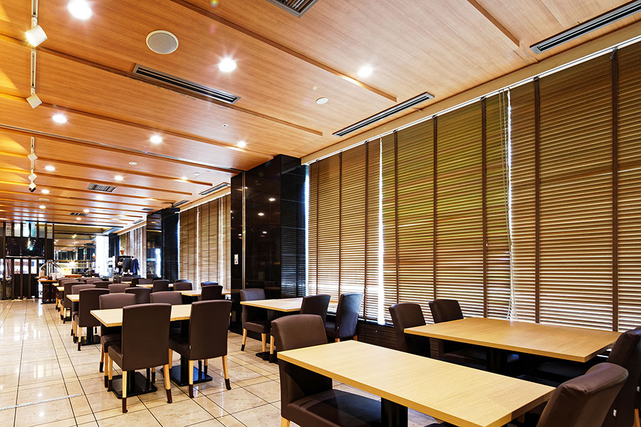 木質天井とブラインドで光環境を整えたレストラン内観（愛知県名古屋市）